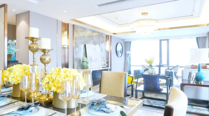 Bright dining and living area in St Albans with elegant gold and yellow decor, modern chandelier, and floral accents designed by Oraanj Interior Design.