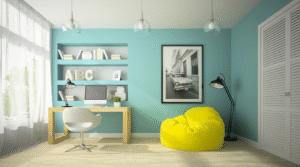 Bright study corner with a turquoise wall, built-in desk and shelves, white swivel chair, yellow bean bag, and framed artwork.