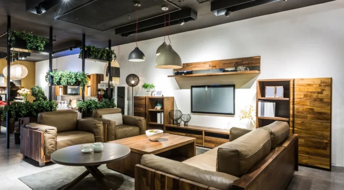 Modern rustic living room designed by Oraanj Interior Design, featuring wooden furniture, leather sofas, pendant lighting, and indoor greenery for a warm and elegant ambiance.