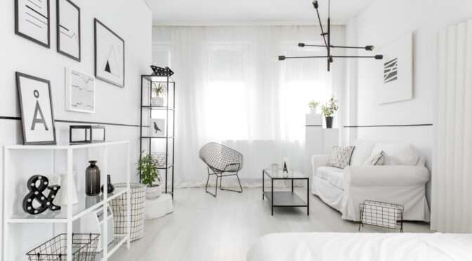 A well-organized small studio flat with a fold-out bed, modular shelving, and light-toned decor to enhance the sense of space.