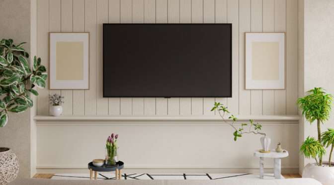 Modern living room with vertical wood wall paneling, TV, indoor plants, and minimalist decor.