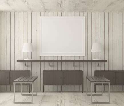 Living room with whitewashed tongue and groove wall, floating shelf, blank wall frame, white table lamps, dark wood cabinets, and nesting tables.