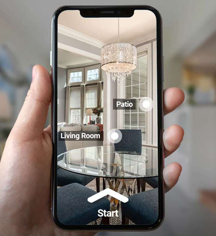 Hand holding smartphone displaying AR interior design app visualizing chandelier and furniture in living room Hand holding smartphone displaying AR interior design app visualizing chandelier and furniture in living room