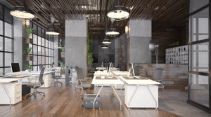 An industrial-style open-plan office with white workstations, ergonomic chairs, exposed wooden ceiling slats, large pendant lights, glass partitions, indoor plants, and warm timber flooring.