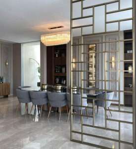Modern dining room with glass table and gold room divider