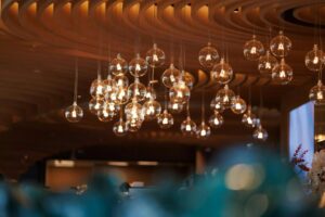 Decorative glass pendant lights suspended from a sculptural ceiling, creating a warm and elegant ambient lighting feature.