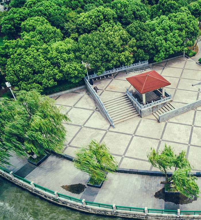 Landscape design for riverside plaza with paved open space, pavilion structure and surrounding trees