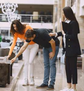 Interior designer assisting couple with furniture selection in showroom for home renovation
