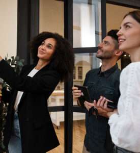 Interior designer showing fabric samples to happy couple during consultation by Oraanj Interior Design
