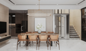 A modern dining room with a long wooden dining table, matching chairs, a minimalist linear pendant light, light wood wall panelling, and a neutral, contemporary interior layout.