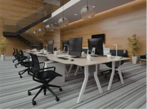 “Modern office workspace with bench-style desks, ergonomic task chairs, desktop computers, glass pendant lighting, and warm wood wall panelling.”