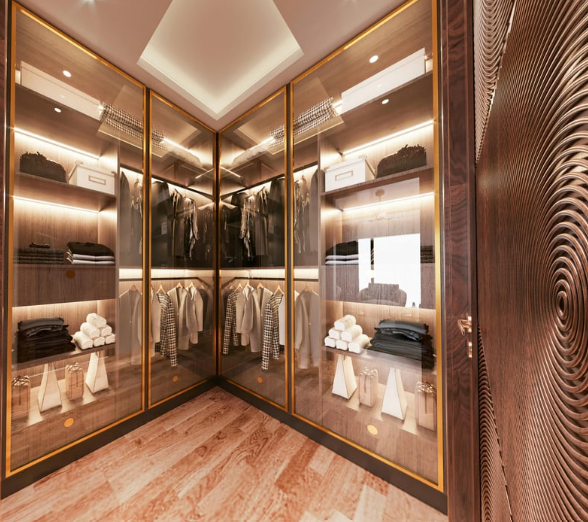 Luxurious walk‑in wardrobe with mirrored gold‑framed panels, LED lighting, wooden shelves holding folded clothes and hanging garments, and a textured wood door.