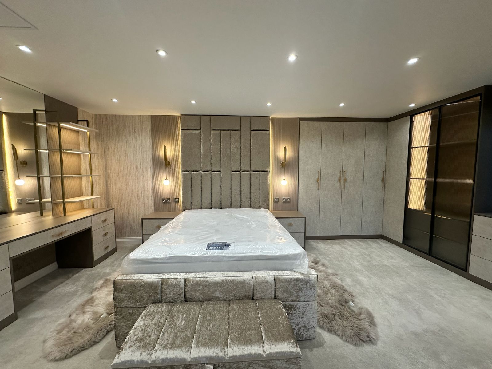 Luxury Bedroom with Dressing Area in London A luxury bedroom featuring bespoke wardrobes, integrated lighting, vanity area, and upholstered bed, showcasing Oraanj Interiors’ attention to detail in London residential design.