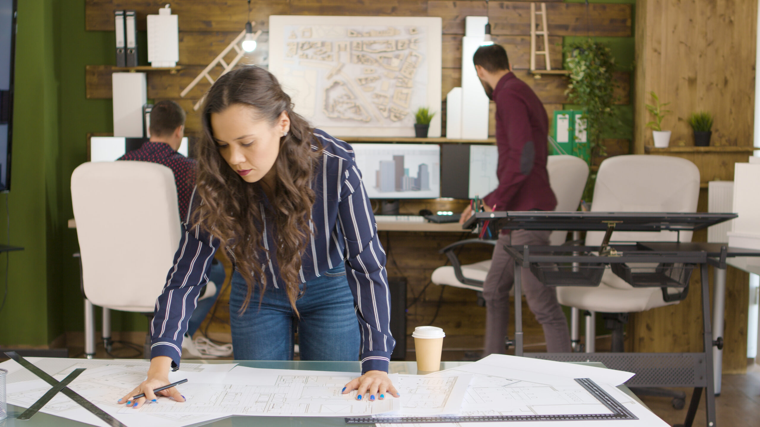 Design professionals reviewing architectural plans inside the Oraanj Interiors London studio, demonstrating concept development, spatial planning, and creative teamwork.